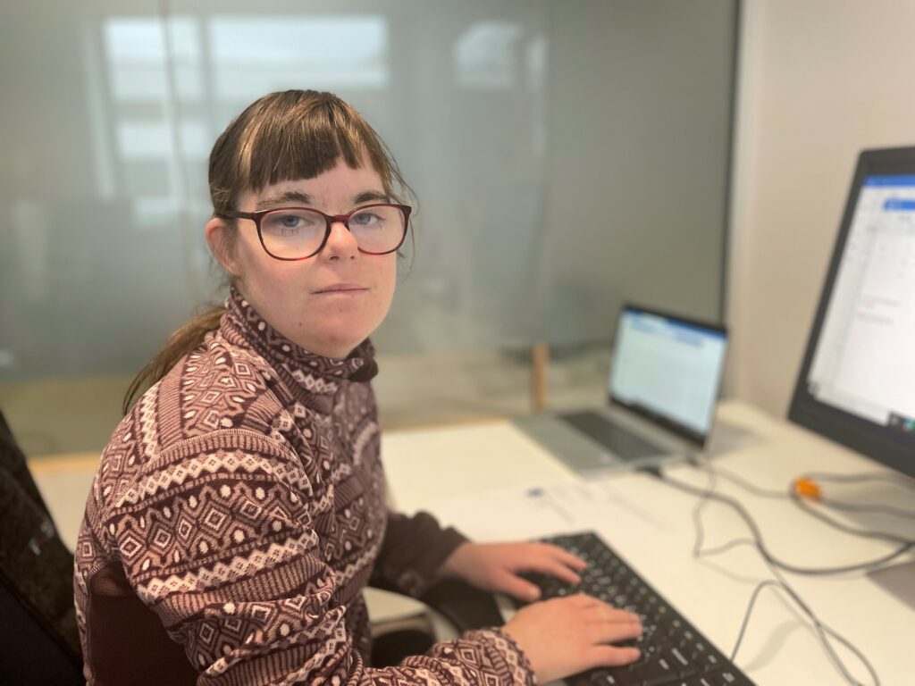 Kvinne med Downs syndrom jobber ved PC
