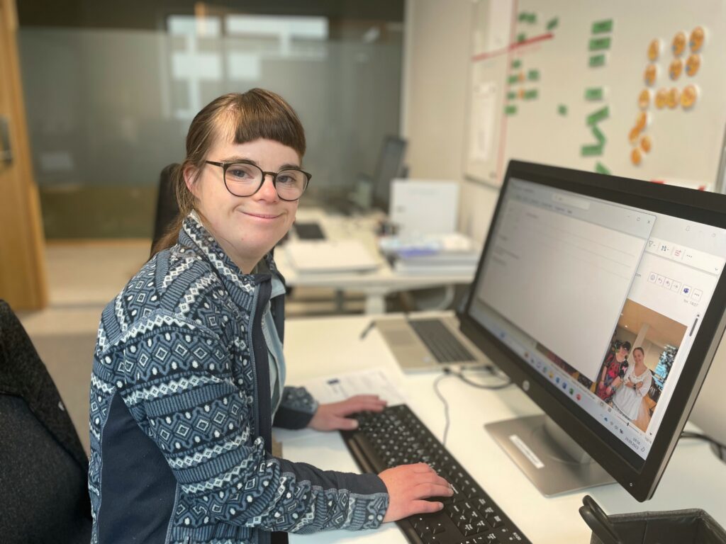 Kvinne med Downs syndrom jobber ved PC